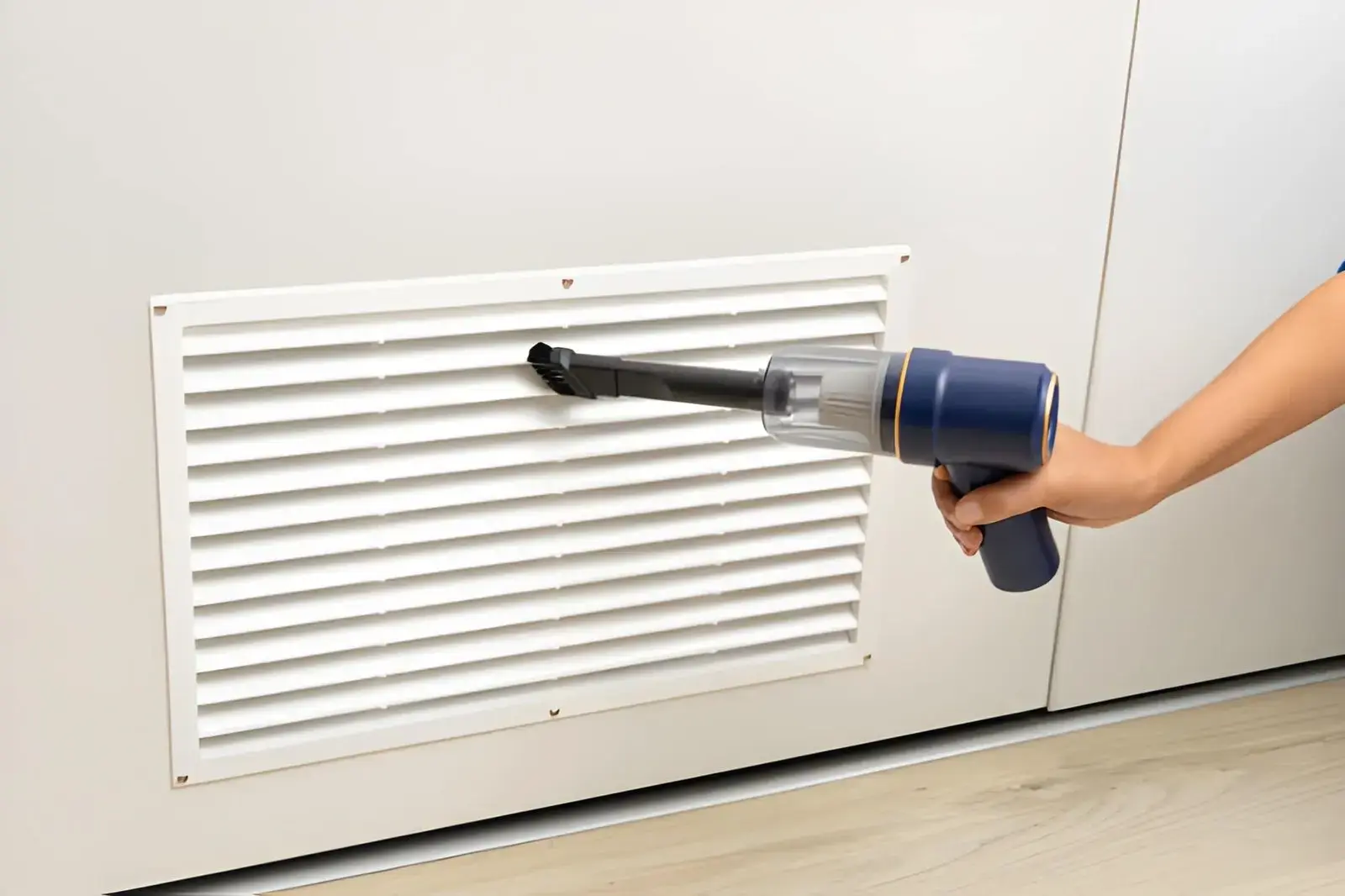 HVAC technician cleaning AC vents to remove dust, debris, and allergens from home ventilation system.