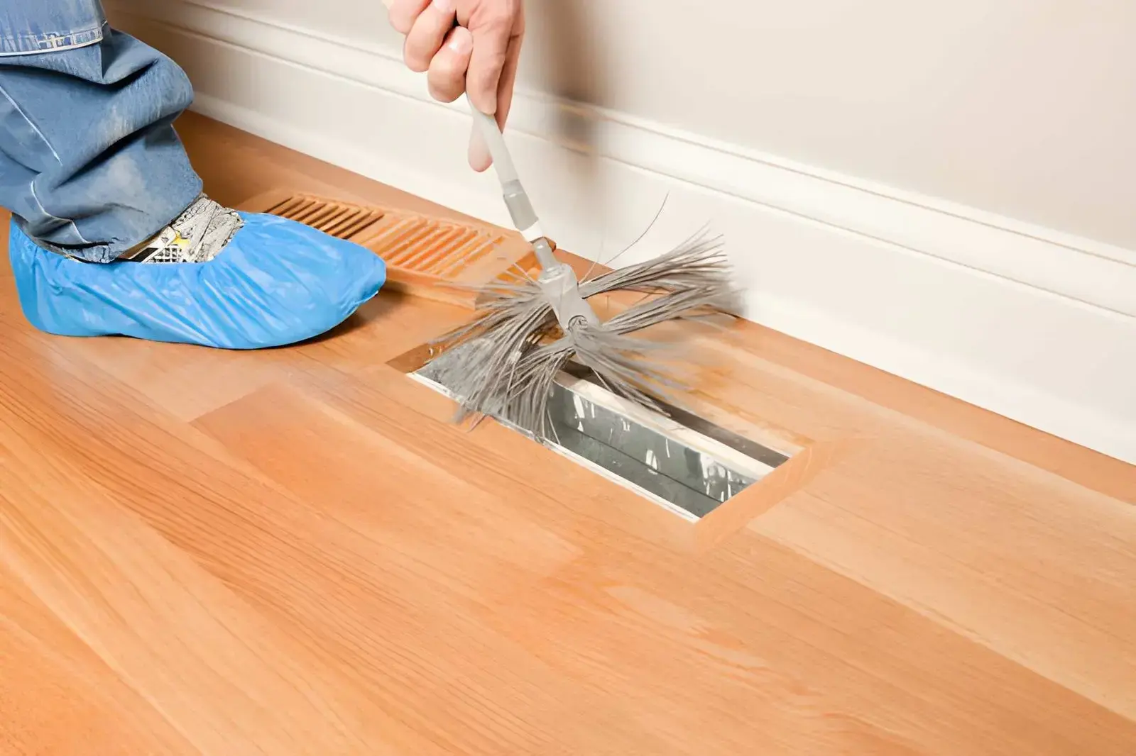 Local technician performing HVAC duct cleaning to remove dust and improve indoor air quality.